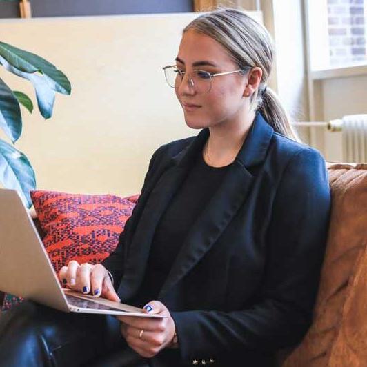 Student sitting on a couch with a laptop